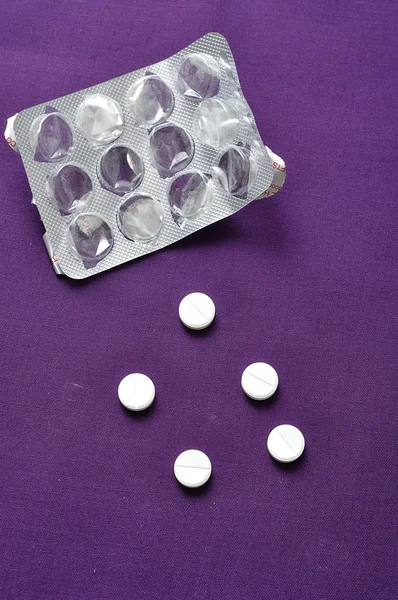 Medicine pills on Purple background with a empty blister pack