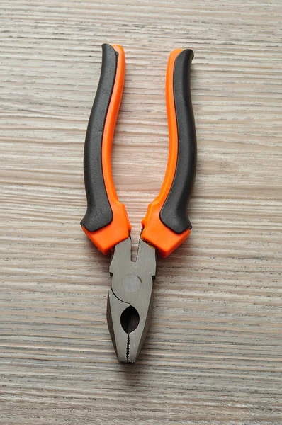 Pliers isolated on a wooden background — Stock Photo, Image