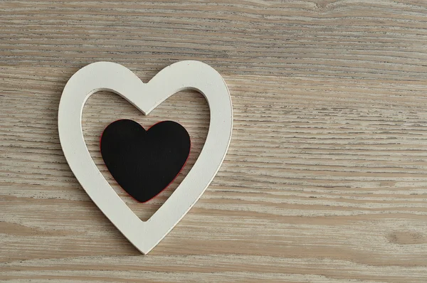 Aftelkalender voor Valentijnsdag. Een witte en zwarte houten harten — Stockfoto