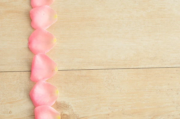 A row of pink rose petals on the left hand side — Stock Photo, Image