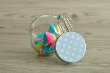 Yarısı şekerle dolu bir polka dot mavi kapaklı bir cam kavanoz