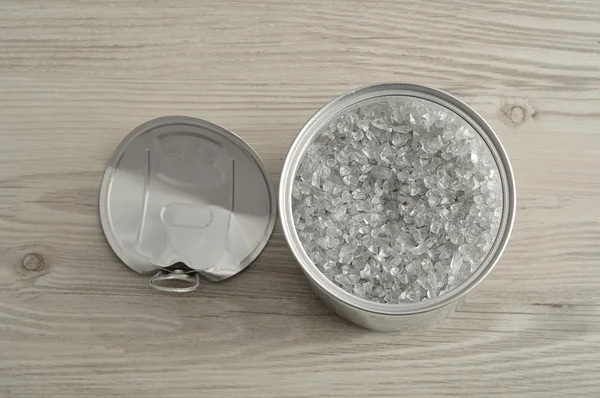 An open see through tin with a metal lid tin next to it — Stock Photo, Image