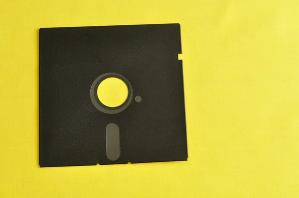 Een enkele floppy-disk geïsoleerd op gele achtergrond — Stockfoto