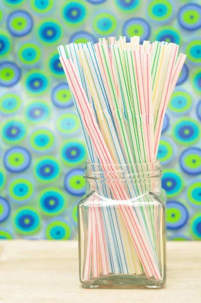 Drinking straws in a bottle with a colorful background — Stock Photo, Image