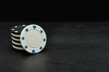 Siyah bir arka plan üzerinde beyaz ve siyah poker fişleri