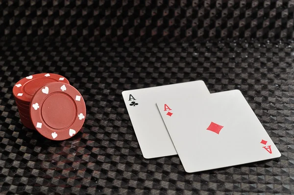 İki kart ile siyah bir zemin üzerine kırmızı poker fişleri — Stok fotoğraf