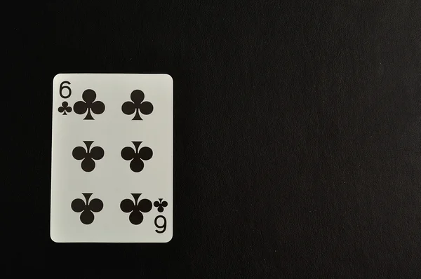 Гральна картка. Шість конюшини ізольовані на чорному тлі — стокове фото