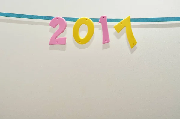 2017 in roze en gele getallen reflecteren op een witte achtergrond — Stockfoto