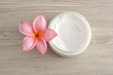 Vücut losyonu pembe frangipani çiçek ile bir kap içinde