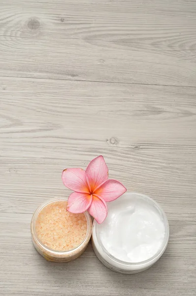 Body lotion and bath salt displayed with a frangipani flower — Stock Photo, Image