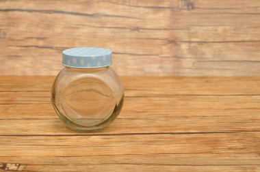 Ahşap arka plan üzerinde izole bir boş cam kap