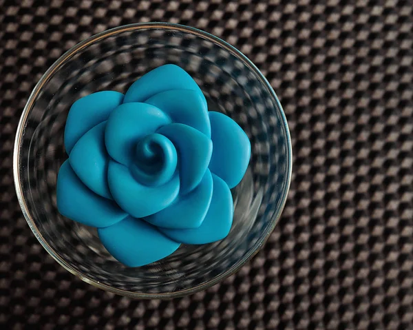 Una rosa de plástico azul en un recipiente de vidrio utilizado para la decoración — Foto de Stock