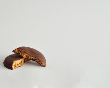 Yuvarlak bir bisküvi yarısında kırık çikolata kaplı