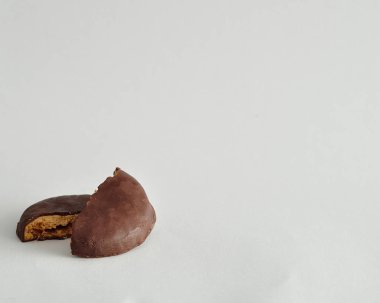 Yuvarlak bir bisküvi yarısında kırık çikolata kaplı