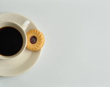 Bir fincan kahve ve bir yuvarlak bisküvi ile dolu