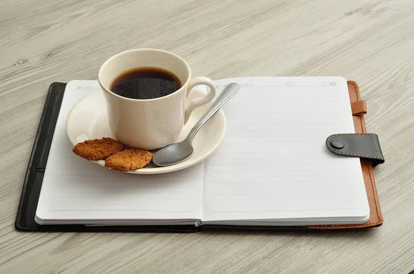 Une tasse de café, des biscuits et un carnet — Photo