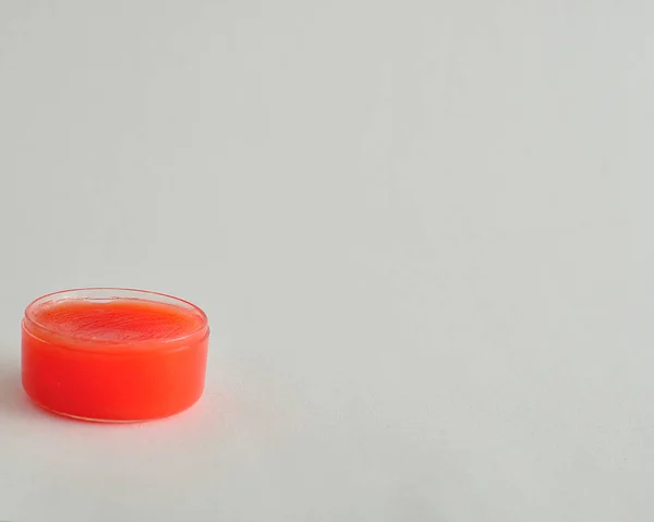 Palma labial roja en un frasco aislado sobre un fondo blanco — Foto de Stock
