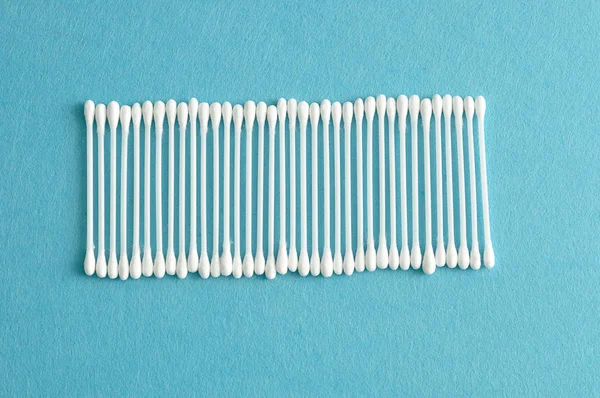 Una fila di tamponi di cotone isolati su uno sfondo azzurro — Foto Stock