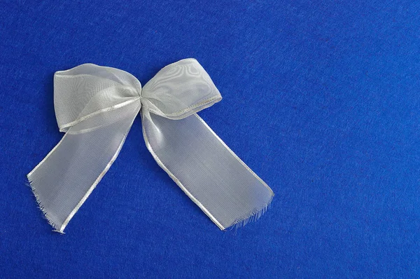 En silver bow isolerade mot en blå bakgrund — Stockfoto