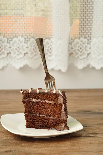 Una fetta di torta al cioccolato con una forchetta — Foto Stock
