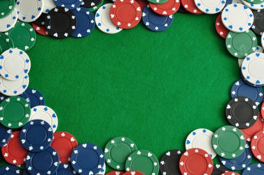 Yeşil bir arka plan ile bir sınır oluşturan poker fişleri