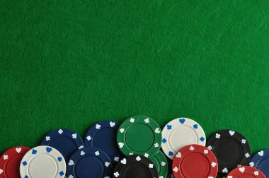 Yeşil bir arka plan ile bir sınır oluşturan poker fişleri
