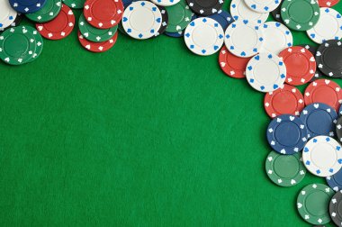 Yeşil bir arka plan ile bir sınır oluşturan poker fişleri