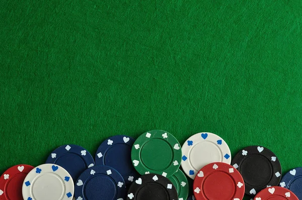Yeşil bir arka plan ile bir sınır oluşturan poker fişleri