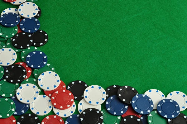 Yeşil bir arka plan ile bir sınır oluşturan poker fişleri