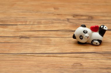 Sevgililer günü. Kırmızı bir kalp tutan bir seramik panda heykelcik 