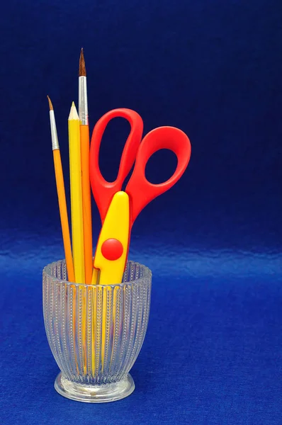 Um recipiente de vidro com tesouras e lápis — Fotografia de Stock