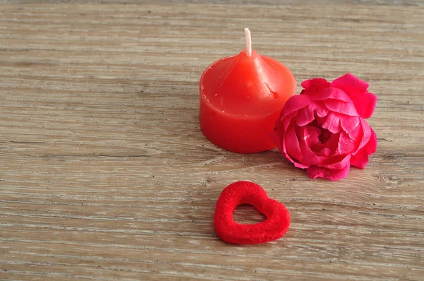 Una vela roja, una rosa rosa y un corazón rojo — Foto de Stock