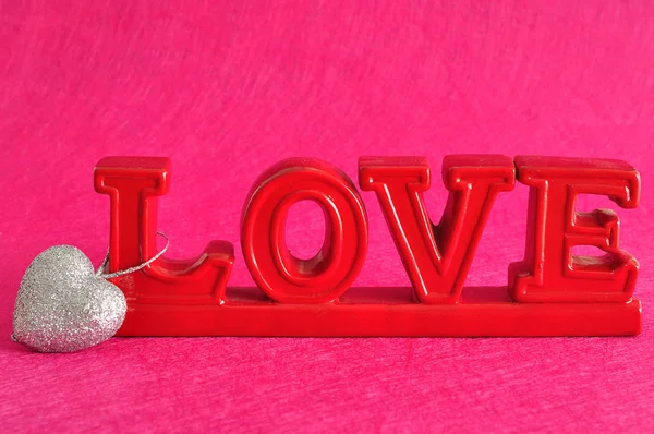 A szerelem szót egy ezüst glitter-szív — Stock Fotó