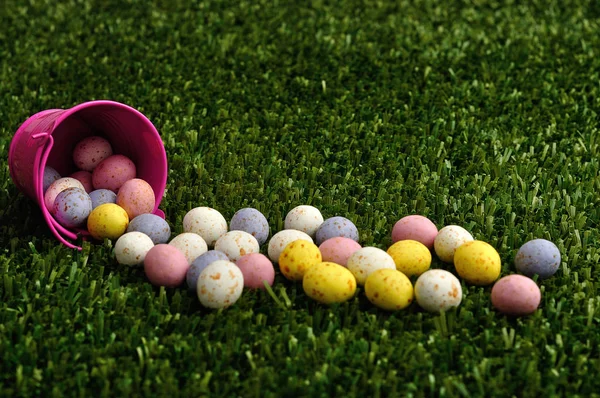 Small speckled easter eggs spilling out of a pink bucket — Stock Photo, Image