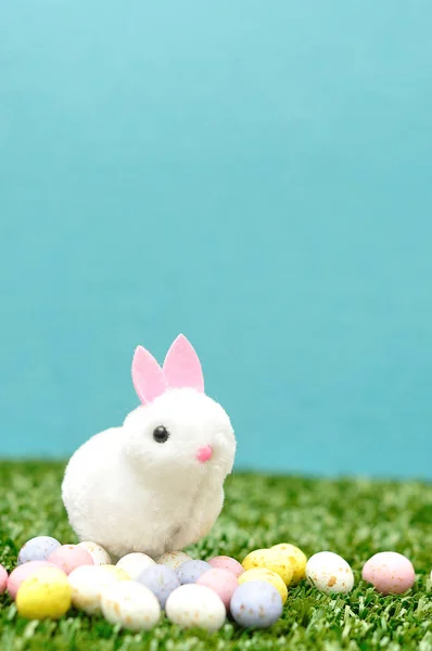 Une figurine de lapin moelleux avec des œufs de Pâques mouchetés — Photo