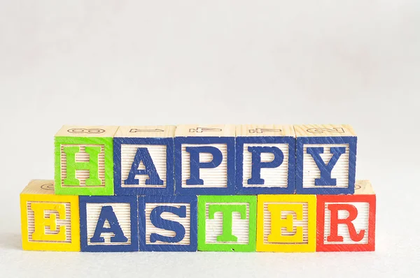 Frohe Ostern buchstabiert mit Buchstabenblöcken — Stockfoto