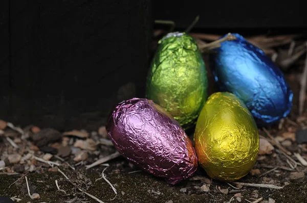 Easter egg wrapped in a shiny wrapper hidden in a garden — Stock Photo, Image
