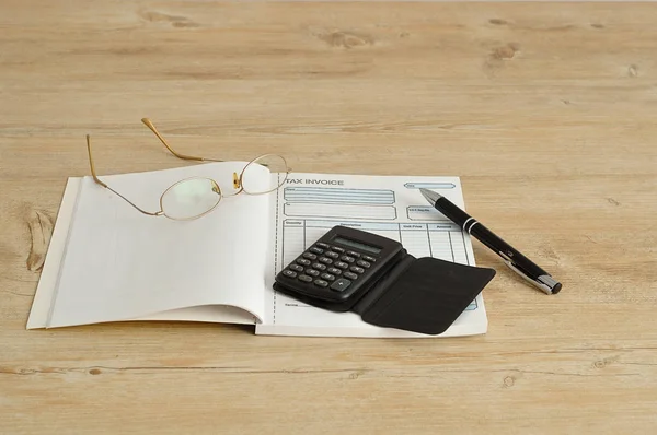 Calculator, pen, glasses and invoice book — Stock Photo, Image