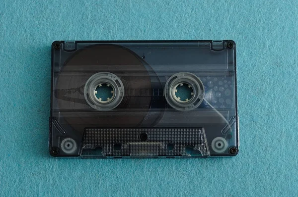 An old tape cassette isolated on a blue background