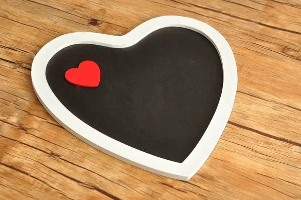 Een zwart bord hart versierd met een rood hart — Stockfoto
