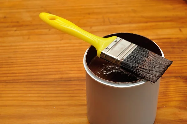 White container filled with paint and a paintbrush — Stock Photo, Image