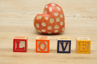  Renkli alfabe blokları ve kırmızı bir kalp ile aşk yazıldığından