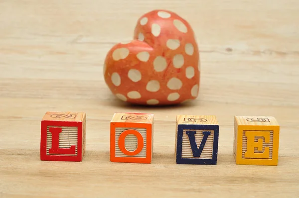Love spelled with colorful alphabet blocks and a red heart