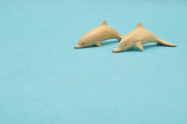 Mavi bir arka plan üzerinde izole iki ahşap yunus figürler