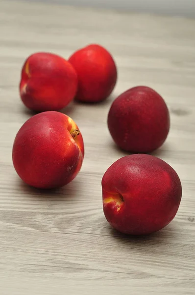 Nectarinas em uma mesa com dept raso de campo — Fotografia de Stock