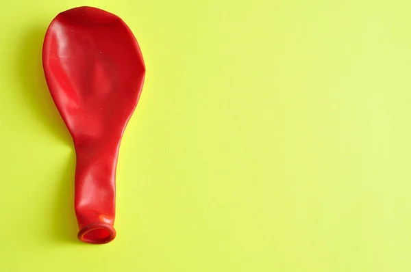 Un único globo rojo aislado sobre un fondo amarillo — Foto de Stock