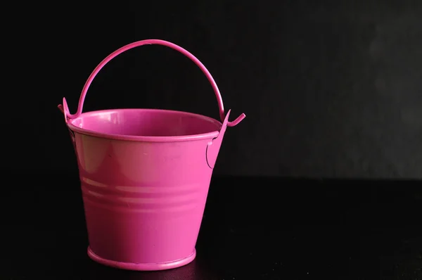 A pink miniature bucket isolated on a black background — Stock Photo, Image