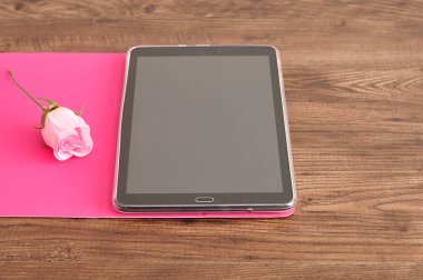 Pembe gül görüntülenen bir pembe tutucu bir tablet