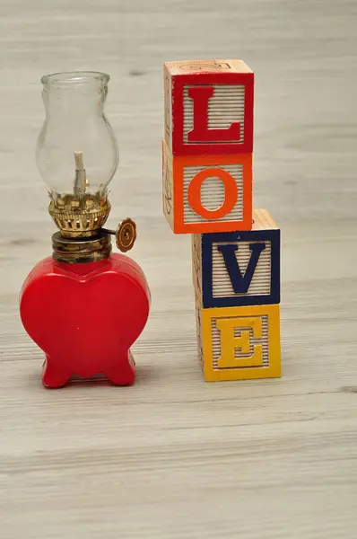 Una lámpara de aceite rojo en forma de corazón con la palabra amor — Foto de Stock