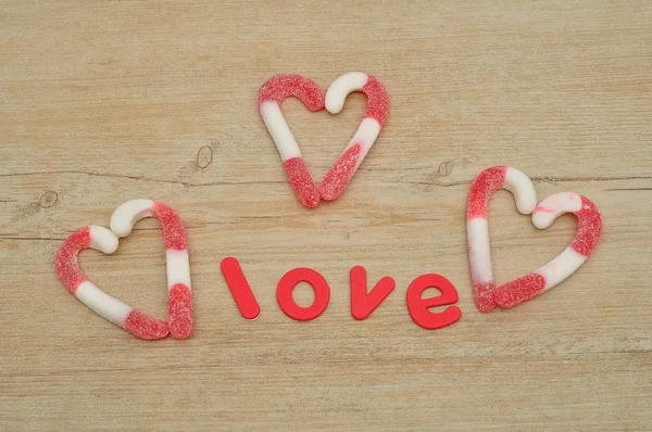 Corações feitos de bengalas doces com a palavra amor — Fotografia de Stock